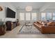 Stylish living room with a large TV, plush leather sofa, and elegant rug at 14493 Promenade Pkwy, Odessa, FL 33556