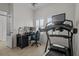 Spacious home office with a treadmill, workstation, and natural light from the window at 14493 Promenade Pkwy, Odessa, FL 33556