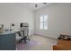 Bright home office featuring a desk, chair, neutral carpet, and plantation shutters at 14493 Promenade Pkwy, Odessa, FL 33556