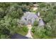 Birds-eye view of a stately home with mature landscaping, a circular driveway, and a prominent chimney at 15053 Peace Blvd, Spring Hill, FL 34610