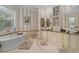 Elegant bathroom with soaking tub, dual vanities, and stylish striped wallpaper at 15053 Peace Blvd, Spring Hill, FL 34610