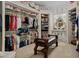 Organized walk-in closet with bench seat and decorative mirror at 15053 Peace Blvd, Spring Hill, FL 34610