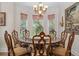 Formal dining room with a round wooden table, upholstered chairs, and a bay window at 15053 Peace Blvd, Spring Hill, FL 34610