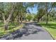 Long driveway through tree-lined property leading to an elegant home with a lush green lawn and inviting atmosphere at 15053 Peace Blvd, Spring Hill, FL 34610