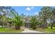 Stunning two-story home featuring a turret, large arched window, brick-lined entryway, mature landscaping and elegant curb appeal at 15053 Peace Blvd, Spring Hill, FL 34610