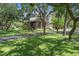 Traditional-style home with a covered front porch, mature trees, and a driveway at 15053 Peace Blvd, Spring Hill, FL 34610