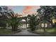 Beautiful exterior view of the two-story home with a turret, large arched window, and lush landscaping at dusk at 15053 Peace Blvd, Spring Hill, FL 34610