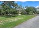 Grand home nestled amidst mature trees, featuring a well-maintained lawn and an inviting front entrance at 15053 Peace Blvd, Spring Hill, FL 34610