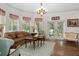 Cozy living room with bay window, chandelier, hardwood floors, and double doors leading to the outside at 15053 Peace Blvd, Spring Hill, FL 34610