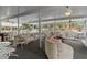Inviting sunroom with abundant seating arrangements, ceiling fans, and panoramic views of the natural landscape at 15053 Peace Blvd, Spring Hill, FL 34610