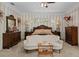 Comfortable main bedroom showcasing a decorative bed, vintage furnishings, and elegant striped wallpaper at 15053 Peace Blvd, Spring Hill, FL 34610