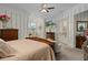 Large main bedroom with vintage furniture, striped wallpaper, large television and ensuite bath at 15053 Peace Blvd, Spring Hill, FL 34610