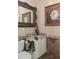 Elegant powder room featuring a granite countertop, vessel sink, and framed mirror and floral art at 15053 Peace Blvd, Spring Hill, FL 34610