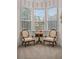 Sitting area with two armchairs, table and large bay window allowing for natural light at 15053 Peace Blvd, Spring Hill, FL 34610