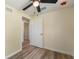 A bedroom with new wood floors, a ceiling fan, and a view into the hallway at 1540 7Th E Ave, Bradenton, FL 34208