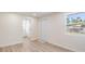 Bright bedroom with a window, showing an open doorway leading to the bathroom and backyard access at 1540 7Th E Ave, Bradenton, FL 34208