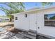 Exterior side entry door showing brick pathway, privacy window, and new lighting at 1540 7Th E Ave, Bradenton, FL 34208