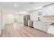 Open concept kitchen with stainless steel appliances, modern cabinetry, and new light-colored floors at 1540 7Th E Ave, Bradenton, FL 34208