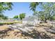 Rear of a single-story home with light-colored siding, a fenced yard, and a concrete slab patio at 1540 7Th E Ave, Bradenton, FL 34208