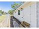 Side exterior with wood siding, stone pathway, metal fence, new lighting, and an entry door at 1540 7Th E Ave, Bradenton, FL 34208