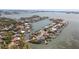 Panoramic aerial view showcasing waterfront homes with boat docks in a scenic bay community at 19 N Pine Cir, Belleair, FL 33756