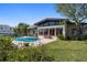 An inviting pool is surrounded by patio space and lush landscaping, perfect for outdoor relaxation and entertainment at 19 N Pine Cir, Belleair, FL 33756