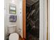 Modern bathroom features a pebble tile shower with a sliding partition and sleek black marble tiling at 19 N Pine Cir, Belleair, FL 33756