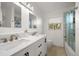 Modern bathroom features dual sinks, marble countertops, sleek fixtures, and a glass-enclosed shower at 19 N Pine Cir, Belleair, FL 33756