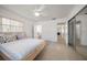 Bright bedroom with neutral tones, a ceiling fan, and easy access to an adjacent bathroom at 19 N Pine Cir, Belleair, FL 33756