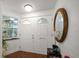 Entryway with decorative doors, a side window, and a round mirror, creating a welcoming ambiance at 19 N Pine Cir, Belleair, FL 33756