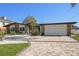 Attractive home featuring stone accents, a paved driveway, and well-maintained landscaping at 19 N Pine Cir, Belleair, FL 33756