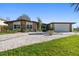 Charming home with stone accents, a paved driveway, and a beautifully landscaped front yard at 19 N Pine Cir, Belleair, FL 33756
