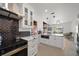 Stylish kitchen with stainless appliances, white cabinetry, and a view of the home's open living space at 19 N Pine Cir, Belleair, FL 33756