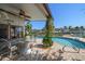 Covered patio with fan and stone table set, plus views of the in-ground pool and waterway at 19 N Pine Cir, Belleair, FL 33756