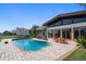 Private pool with a brick patio and home featuring large windows for ample natural light at 19 N Pine Cir, Belleair, FL 33756