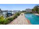 A sparkling pool sits next to a waterway with a private boat dock and lift, great for waterfront enjoyment at 19 N Pine Cir, Belleair, FL 33756