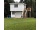 Two-story white building featuring a garage, stairs leading to a deck, and a grassy lawn at 22129 Carson Dr, Land O Lakes, FL 34639