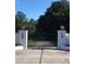 Elegant gated entrance with white pillars and decorative lanterns, leading to a private driveway at 22129 Carson Dr, Land O Lakes, FL 34639