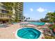 Outdoor pool and jacuzzi with comfortable lounge chairs, blue skies and nearby palm trees at 2413 Bayshore Blvd # 801, Tampa, FL 33629