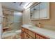 Bathroom featuring vanity, toilet, mirror and shower with built-in seat at 2557 Laurelwood Dr # 10E, Clearwater, FL 33763