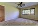 Neutral bedroom features a ceiling fan and a large window providing ample light at 2557 Laurelwood Dr # 10E, Clearwater, FL 33763