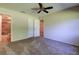 A bright carpeted bedroom features a ceiling fan and closet and en-suite bathroom at 2557 Laurelwood Dr # 10E, Clearwater, FL 33763