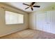 Neutral bedroom features a ceiling fan, closet and large window at 2557 Laurelwood Dr # 10E, Clearwater, FL 33763