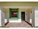 Inviting front porch with a green front door, a brick-laid porch floor, and green trim window at 2557 Laurelwood Dr # 10E, Clearwater, FL 33763
