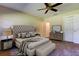 Staged main bedroom features a tufted headboard and ceiling fan at 2557 Laurelwood Dr # 10E, Clearwater, FL 33763