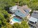 An aerial shot showcasing the pool in the backyard, as well as the surrounding lush greenery and neighborhood at 322 Ontario Ave, Crystal Beach, FL 34681