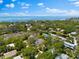 Beautiful aerial view of a coastal neighborhood with lush trees and a glimpse of the ocean in the background at 322 Ontario Ave, Crystal Beach, FL 34681