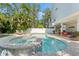 Beautiful backyard with a pool, hot tub, patio, and lounging area, ideal for outdoor entertaining at 322 Ontario Ave, Crystal Beach, FL 34681