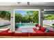 Covered outdoor living space overlooking a private pool and spa area with comfortable seating and tropical landscaping at 322 Ontario Ave, Crystal Beach, FL 34681