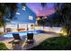 Exterior of the house showcasing a pool, hot tub, outdoor seating, and tropical landscaping at 322 Ontario Ave, Crystal Beach, FL 34681
